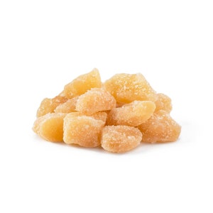 May include: A close-up of a pile of candied ginger. The ginger is a light brown color and has a slightly translucent appearance. The ginger is coated in a thin layer of sugar crystals.