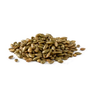 May include: A close-up of a pile of roasted pumpkin seeds. The seeds are green and have a slightly salty look.