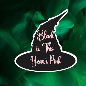 May include: Black witch hat with the text "Black is This Year's Pink" in pink lettering.