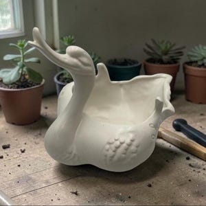 May include: A set of three ceramic mugs with a speckled, matte finish. The mugs are in shades of cream, light brown, and dark brown. Each mug has a simple, minimalist design, perfect for coffee or tea.