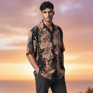 May include: A short-sleeved button-down shirt in black featuring a repeating tropical print of pineapples and green palm leaves in shades of orange, pink, and tan. The shirt has a classic collar, a straight hem, and a relaxed fit throughout.