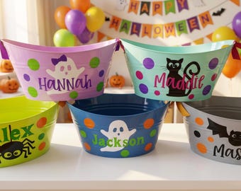 May include: Five oval metal buckets in light purple, light blue, lime green, dark blue, and gray, each featuring colorful polka dots and personalized names. The buckets display graphic icons including a ghost, a black cat, a spider, and a bat.