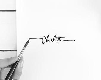 May include: A black and white image of the name Charlotte written in cursive script. A paintbrush is being used to trace the name.