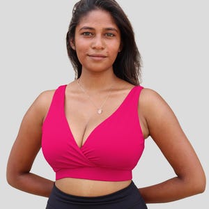 Può includere: Un reggiseno sportivo rosa acceso con scollo a V profondo e design avvolgente. Il reggiseno ha spalline regolabili e una vestibilità comoda.