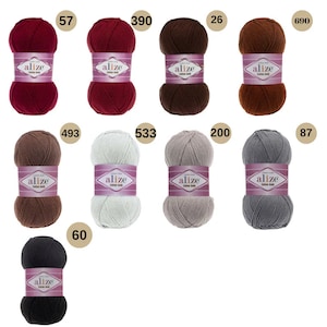 May include: Assortment of ten balls of yarn in various colours, including red, brown, beige, grey, and black. Each ball has a label that reads "alize cotton gold".