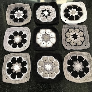 May include: Nine crocheted squares in black, white and grey with a starburst pattern in the centre of each square.