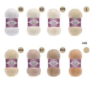 May include: A collection of ten balls of yarn in various shades of white, beige, and brown. The yarn is labelled "alize Cotton Gold" and the balls are numbered 55, 62, 599, 1, 458, 67, 262, 446.