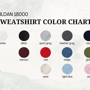 May include: Color chart for Gildan 18000 sweatshirts, showing 12 different colors: white, black, sport grey, heather grey, navy, maroon, red, indigo, green, sand, light blue, and pink.