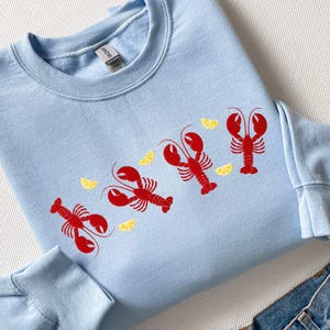 Sudadera con langosta bordada: cuello redondo náutico Coquette