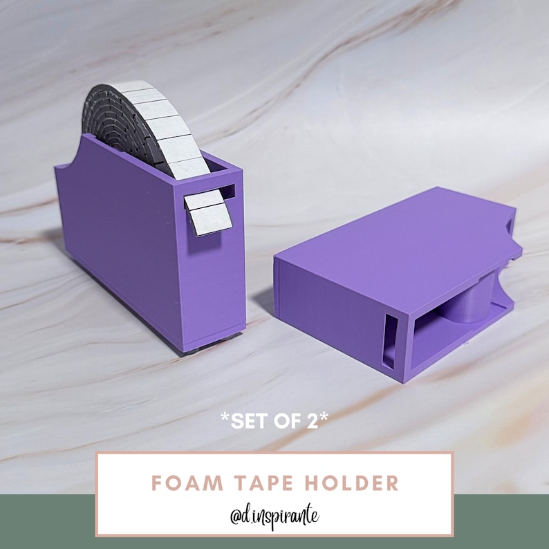 May include: Two purple foam tape holders. One holder contains a roll of foam tape. The other holder is empty. The text on the image says "FOAM TAPE HOLDER" and "*SET OF 2*".