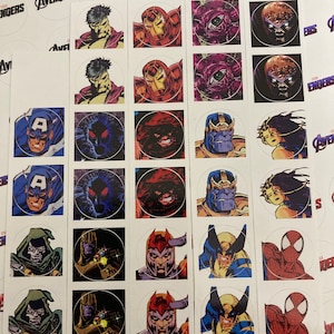 Puede incluir: Una colección de pegatinas cuadradas con varios personajes de cómics de Marvel, incluyendo Hulk, Iron Man, Capitán América y Thanos. Cada pegatina tiene una imagen circular de un personaje.