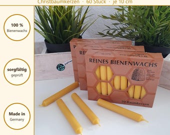 Könnte beinhalten: Drei Schachteln mit gelben Bienenwachskerzen mit Wabenmuster auf der Verpackung. Der Text auf den Schachteln lautet REINES BIENENWACHS und 20 Baumkerzen. Vier einzelne gelbe Kerzen liegen vor den Schachteln auf einer weißen Oberfläche.
