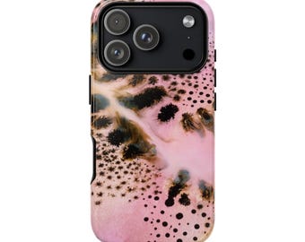 Puede incluir: Una funda para smartphone con fondo rosa claro, salpicada de manchas negras similares a tinta y patrones fluidos abstractos en marrón oscuro y negro. La funda tiene un recorte negro para la cámara con tres aberturas circulares.