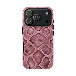 May include: A smartphone case featuring a pink and black snakeskin pattern. The case has a rectangular camera cutout at the top left containing three circular lenses and a flash. The design covers the entire back surface of the phone case.