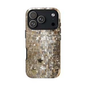 Puede incluir: Una funda para smartphone con un diseño tipo mosaico en tonos beige, marrón y gris. La funda presenta una superficie texturizada y tres recortes de estrellas doradas. Las lentes de la cámara son visibles en la parte superior.