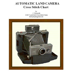 May include: Cross stitch chart titled "AUTOMATIC LAND CAMERA" featuring a vintage camera design. The chart includes the text "Laird-Jim's Cross Stitch Charts" and the copyright information. The image is framed in a brown border.