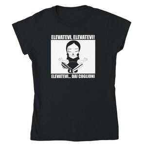 May include: Black and white graphic t-shirt featuring a cartoon girl meditating with the text "Elevatevi, Elevatevi! Elevatevi... Dai Coglioni"