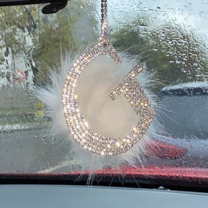 Adorno colgante para espejo retrovisor con piedra de cristal y letra G emplumada