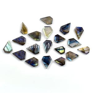 May include: Assortment of 18 labradorite gemstone cabochons in various shades of blue, green, and gold. The cabochons are faceted and have a unique iridescent sheen.