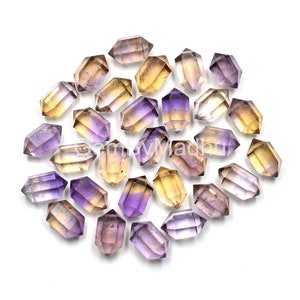 May include: A collection of 20 amethyst and citrine double terminated points. The points are a mix of yellow, orange, and purple colors. The points are arranged in a circle on a white background.