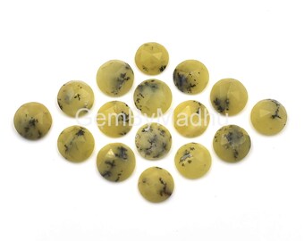 May include: A collection of 15 round, yellow opal cabochons with black dendritic inclusions. The cabochons are approximately 10mm in diameter and have a smooth, polished surface.