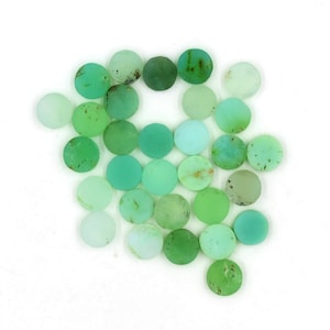 May include: A collection of 25 round, green, and translucent cabochon gemstones. The stones are various shades of green, from light to dark.