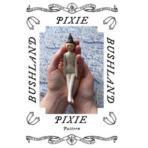 Könnte beinhalten: Eine weiße Filz-Pixie-Puppe mit schwarzen Haaren und einem schwarzen Hut. Die Puppe sitzt in den Handflächen einer Person. Der Hintergrund ist ein blaues und weißes Blumenmuster. Der Text "PIXIE Pattern" befindet sich unter der Puppe.