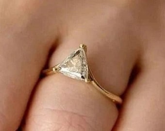 May include: A gold ring with a triangular shaped diamond.
