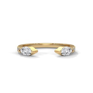 Op de afbeelding: Een gouden ring met twee marquise-vormige diamanten en kleinere diamanten die in de band zijn gezet.