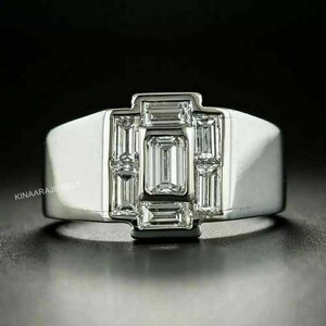 May include: A silver ring with a large, rectangular, emerald-cut diamond surrounded by smaller, rectangular diamonds.