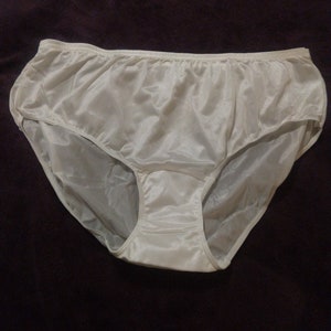 May include: Off-white satin underwear with a high-waisted design. The garment has a smooth, shiny texture and a comfortable fit. The underwear is made of a lightweight material.