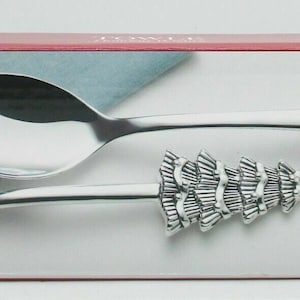 May include: Towle Holiday Wishes silver serving set with a spoon and fork featuring a Christmas tree design. The box reads "Merry Christmas!" and "Salad Serving Set".
