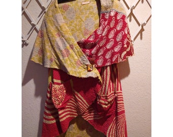May include: A red, yellow, and white kantha quilt wrap with a button closure. The wrap is made of recycled saris and has a unique, hand-stitched design.