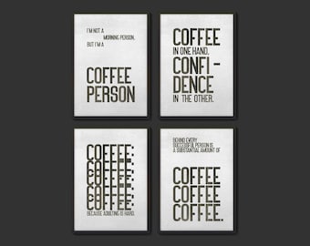 May include: Four black and white printable wall art prints with coffee-themed quotes. The first print says "I'm not a morning person but I'm a coffee person". The second print says "Coffee in one hand, confidence in the other". The third print says "Coffee: because adulting is hard". The fourth print says "Behind every successful person is a substantial amount of coffee, coffee, coffee."
