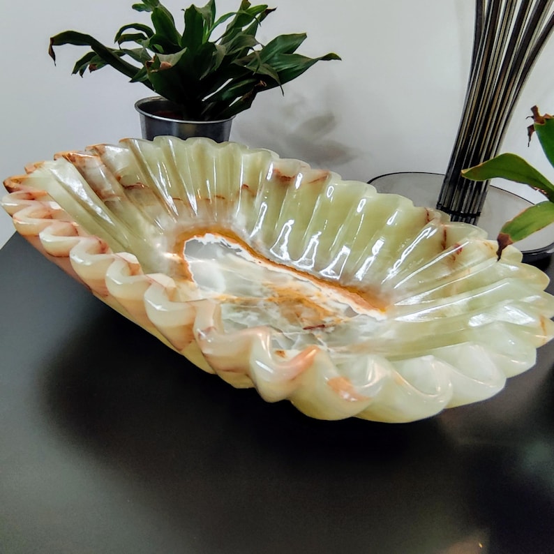 Puede incluir: Un cuenco decorativo oblongo de &oacute;nix verde claro transl&uacute;cido. El cuenco tiene un borde con volantes con un ribete color crema y melocot&oacute;n. El interior presenta un patr&oacute;n arremolinado de blanco, marr&oacute;n y verde.