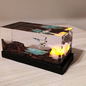 X-Wing Diorama with LED Thrusters: This resin sculpture of an X-Wing captures the essence of a thrilling Star Wars launch, with LED lights simulating the ship's thrusters as it takes flight.