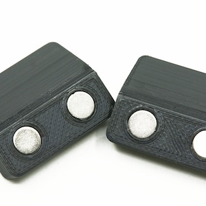May include: Two black plastic magnetic clips with two silver magnets on each clip.
