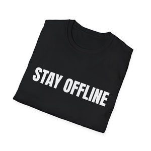 Può includere: T-shirt nero con la scritta bianca "STAY OFFLINE" stampata sul davanti. La maglietta è piegata e sembra essere realizzata in un materiale morbido. La maglietta è a girocollo.