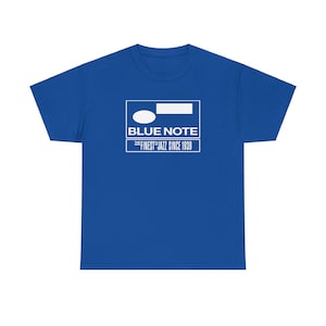 Op de afbeelding: Een koningsblauw T-shirt met een wit grafisch ontwerp. De witte rechthoek toont "BLUE NOTE" en "THE FINEST JAZZ SINCE 1939". Het ontwerp bevat een ovaal en een rechthoek. Het T-shirt heeft een ronde hals.