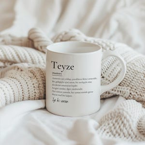 Pu&ograve; includere: Una tazza in ceramica bianca con un design nero che dice "Teyze [Keziban] Annenin can yoldaşı, &ccedil;ocukların ikinci annesidir. Bir g&uuml;l&uuml;ş&uuml;yle i&ccedil;ini ısıtan, bir sarılışıyla t&uuml;m dertlerini unutturan kişidir. Sevgisi candan, ilgisi y&uuml;rektendir. Her zaman yanında, her zaman seninle gurur duyan &ouml;zel bir kalptir. İyi ki varsın"