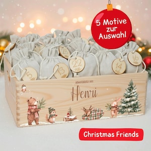 Könnte beinhalten: Eine helle Holzkiste gefüllt mit kleinen Stoffbeuteln mit Kordelzug, die jeweils mit einem runden Holzanhänger mit einer Zahl versehen sind. Die Kiste ist mit Illustrationen von Bär, Eichhörnchen, Reh, Hase und Tannenbaum sowie dem Namen Henri bedruckt.