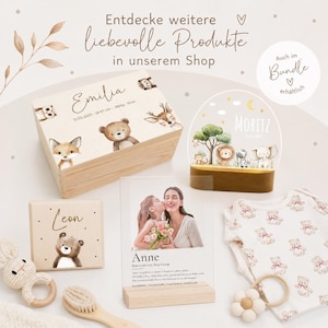 May include: A collection of baby-themed products, including a wooden box with animal illustrations and the name "Emilia", a night light with the name "Moritz", a photo frame, a baby onesie, and a wooden toy. The image includes the text "Entdecke weitere liebevolle Produkte in unserem Shop".