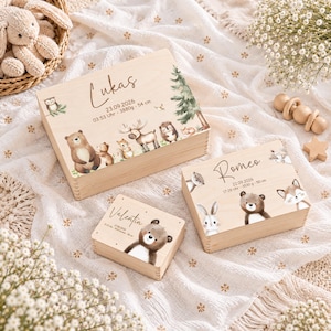 May include: Three rectangular wooden keepsake boxes featuring printed forest animal illustrations and personalised text. The largest box displays the name Lukas, the medium box displays Romeo, and the smallest box displays the name Valentin, each with birth details.