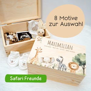 May include: A wooden keepsake box with a safari animal design, personalized with the name "MAXIMILIAN". The box contains baby items, including booties, a bib, and a wooden teether. The text "Safari Freunde" is also visible.
