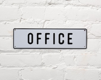 May include: White rectangular metal sign with black border and black text that reads "OFFICE".