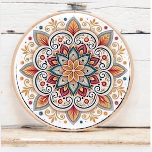 Op de afbeelding: Een ronde borduurring met een gedetailleerd mandala-ontwerp. De mandala heeft een centrale bloemvorm in geel en blauwgroen, omringd door rode, oranje en goudkleurige bladeren. Het ontwerp is geplaatst tegen een witte achtergrond.