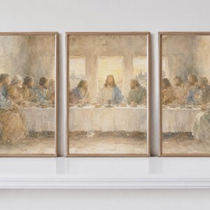 May include: A triptych of framed wall art prints depicting the Last Supper in a muted watercolor style. The three vertical panels show a central figure seated at a long table with disciples, rendered in soft beige, blue, and white tones.