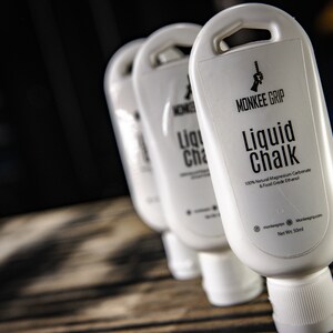 May include: Three white bottles of liquid chalk labelled "Monkee Grip Liquid Chalk 100% Natural Magnesium Carbonate & Food Grade Ethanol Net Wt. 5 fl oz"