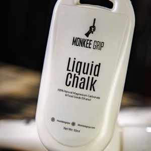 May include: White plastic bottle of liquid chalk with a black label that says "MONKEE GRIP Liquid Chalk 100% Natural Magnesium Carbonate & Food Grade Ethanol" and "monkeegrips Monkeegrip.com Net Wt: 50ml".