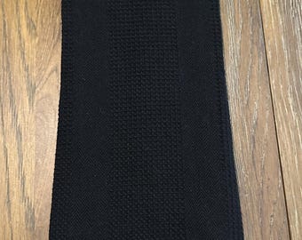 May include: Black kitchen towel with a black and white checkered fabric pocket and a black button.